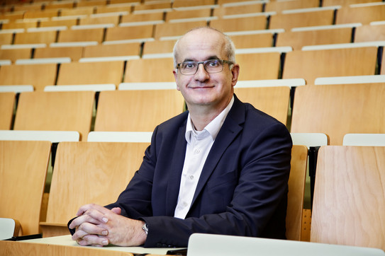 Rektor_Prof_Manfred_Bayer Porträt von Prof. Manfred Bayer auf den Stühlen eines Hörsaals