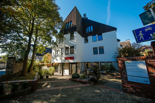 Ein Blick auf die Einfahrt zum Gästehaus. Das Gästehaus liegt in der Mitte des Bildes und ist gut zu erkennen.
